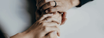Hands gently holding each other, showing support and connection.